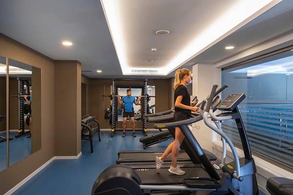 Fitnessstudio im Faros Hotel Ayia Napa mit zwei Personen auf Laufbändern.