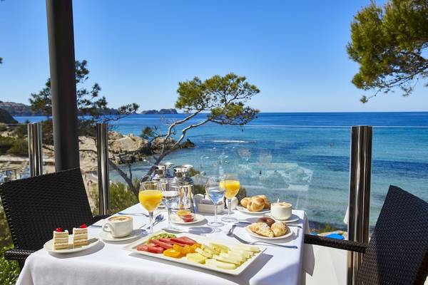 Frühstück am Meer im Lido Park Hotel mit Blick auf das kristallklare Wasser und eine grüne Landschaft.