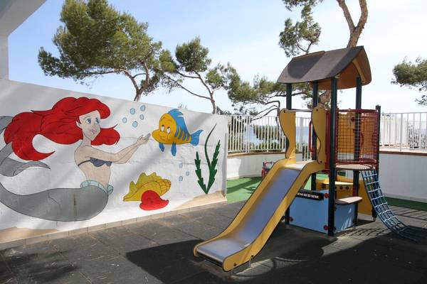 Ein Kinderspielplatz im Lido Park Hotel mit einer Arielle-Wandmalerei und einem gelben Rutschen.