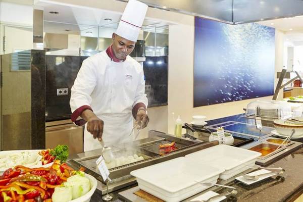 Koch im Restaurant des Marques Hotel beim Kochen mit einem Kochlöffel.