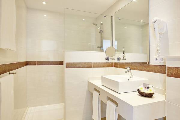 Badezimmer im Marques Hotel mit Dusche, Waschbecken und Handtüchern.