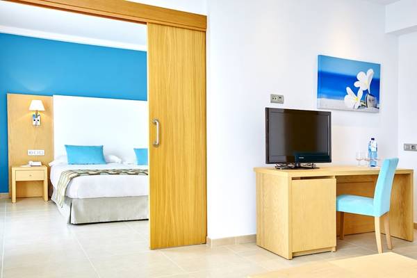Hotelzimmer im Marques Hotel mit Bett, Schreibtisch und Fernseher.