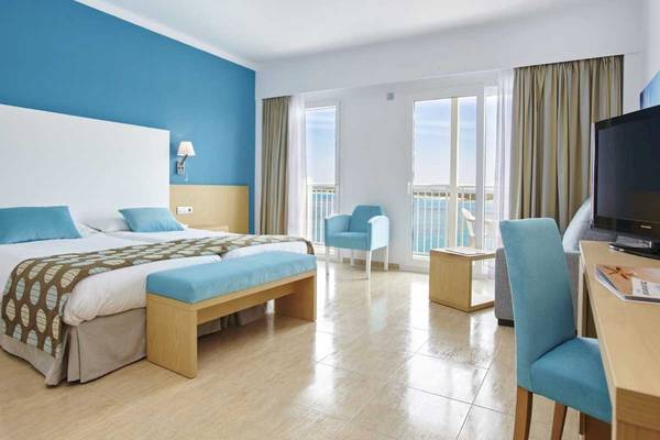 Doppelzimmer im Marques Hotel mit Balkon, zwei Betten, blauen Möbeln und Meerblick.