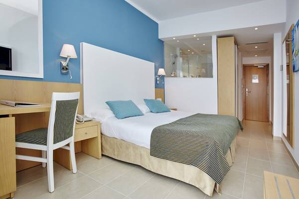 Ein modernes Hotelzimmer im Marques Hotel mit einem Doppelbett, Schreibtisch und einem Badezimmer.
