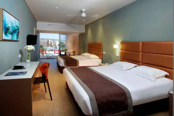 Doppelzimmer im Faros Hotel Ayia Napa mit zwei Betten, Schreibtisch, Fernseher und Stadtblick.