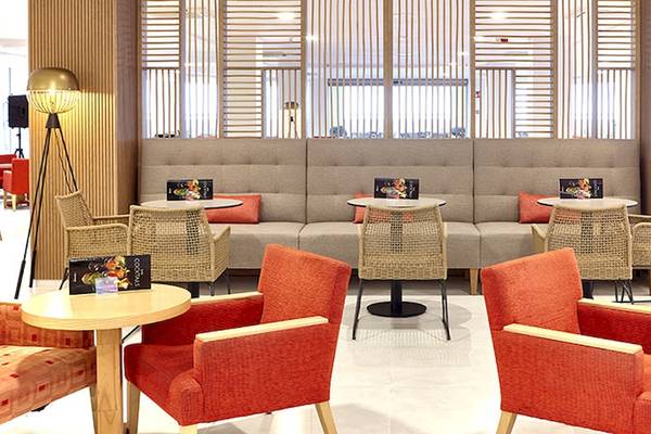 Lobbybereich des Perla Hotels mit Sitzmöbeln und Tischen, dekorativ beleuchtet.