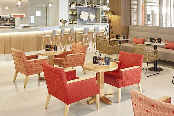 Der Loungebereich im Perla Hotel mit Bar, Sitzgruppen und Tischen.