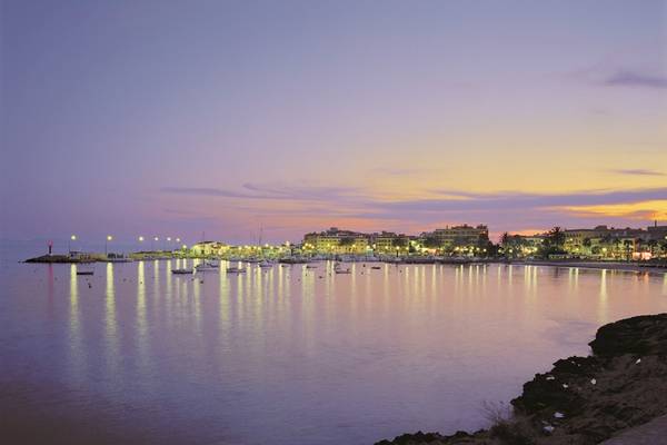 Der Hafen des Romantica Hotels bei Sonnenuntergang mit vielen Booten und Gebäuden im Hintergrund.