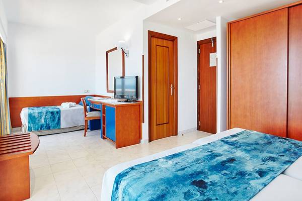 Innenansicht eines Doppelzimmers im Romantica Hotel mit zwei Betten, Schreibtisch und Fernseher.