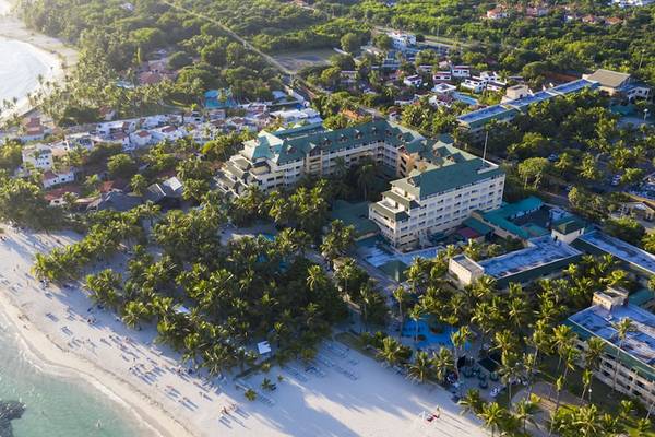 Außenansicht des Coral Costa Caribe Beach Resorts am Strand mit Gebäuden und Palmen