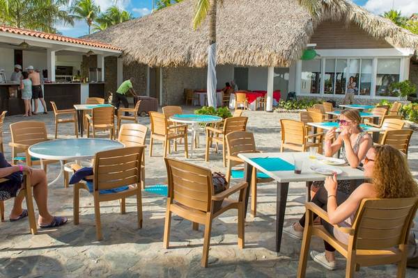 Gäste sitzen in der Außenbar des Coral Costa Caribe Beach Resorts.
