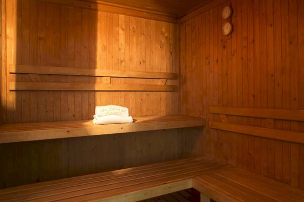 Sauna im Coral Costa Caribe Beach Resort mit leeren Holzbänken und Handtüchern.