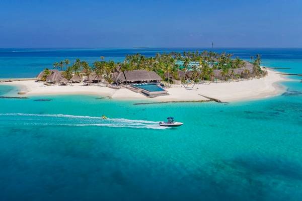Luftaufnahme des Fushifaru Maldives Resorts mit weißen Sandstrand, blauem Wasser und mehreren Bungalows.