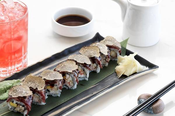 Sushi-Platte mit Gold bedeckt auf einem Teller neben einem Getränk im Katikies Villas Mykonos Hotel.