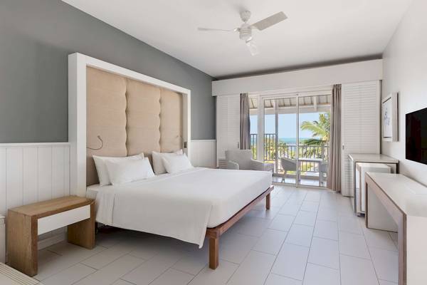 Zimmer im Radisson Blu Azuri Resort & Spa mit Blick auf das Meer und einen Balkon.