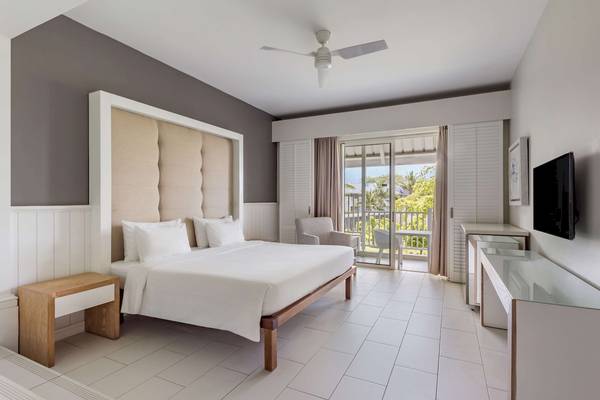 Schlafzimmer im Radisson Blu Azuri Resort & Spa mit Doppelbett, Nachttischen und Balkonzugang.