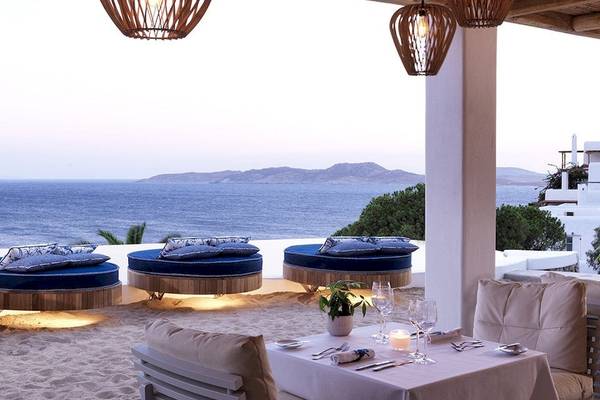 Außenbereich der Katikies Villas Mykonos mit Blick auf das Meer und blauen Kissen.