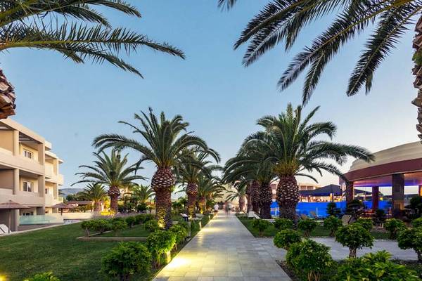 Außenbereich des Sandy Beach Hotels in Kos mit Palmen und Gebäuden