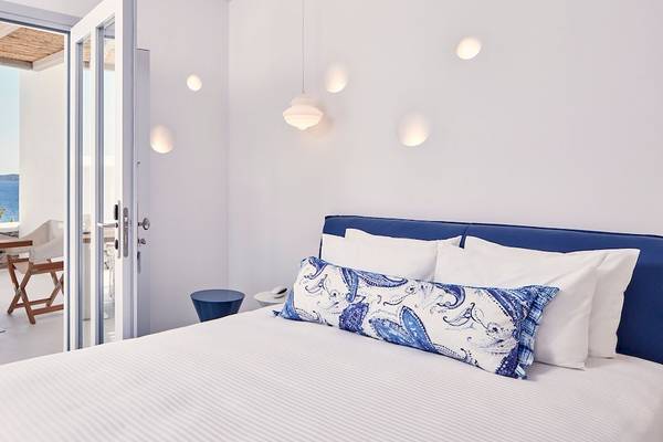 Zimmer im Katikies Villas Mykonos mit Blick auf das Meer und einem Tisch draußen