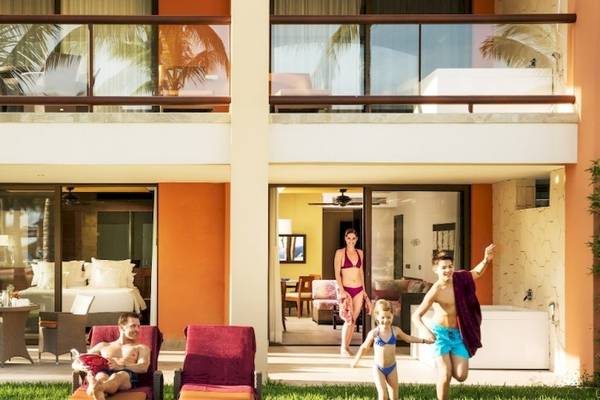 Familie genießt Urlaub im Barcelo Maya Beach Hotel mit Außenbereich, Liegestühlen und Pool.