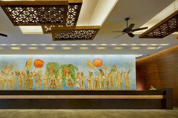 Lobby-Eingang des Barcelo Maya Beach Hotels mit großer Wandmalerei und Deckenventilatoren.