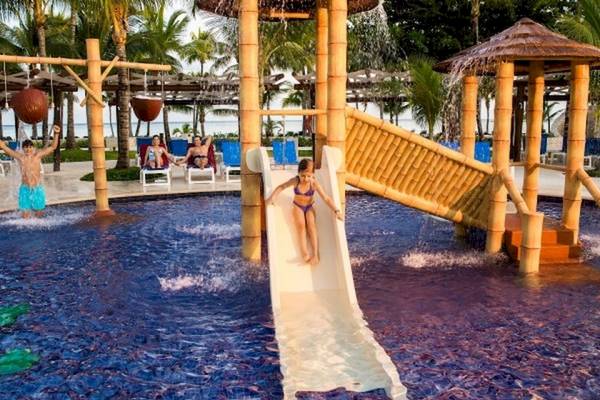 Kinder, die in einem Wasserrutsche im Barcelo Maya Beach Hotel spielen.