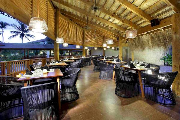 Innenansicht des Restaurants des Grand Palladium Palace Resort & Spa mit runden Tischen und Stühlen.