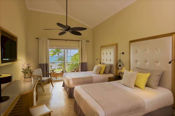 Zwei Betten im Hotelzimmer des Grand Palladium Palace Resort & Spa mit Meerblick.