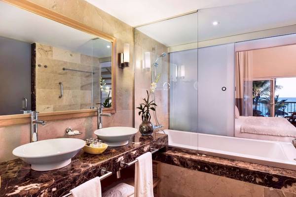 Badezimmer im Grand Palladium Palace Resort & Spa mit Marmoroberflächen, Badewanne und Meerblick.