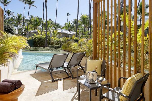 Terrasse mit Liegestühlen und Pool im Grand Palladium Palace Resort & Spa