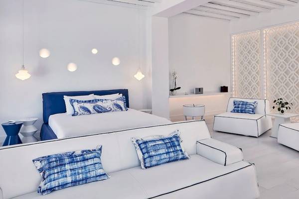 Weißes Schlafzimmer in Katikies Villas Mykonos mit modernen Möbeln und blauen Akzenten.