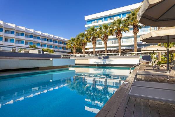 Poolbereich des Blue Sea Beach Resorts mit Sonnenliegen und Palmen.