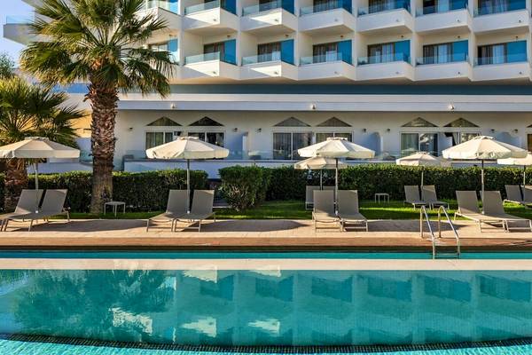 Außenbereich des Blue Sea Beach Resorts mit Swimmingpool, Sonnenliegen und Sonnenschirmen.
