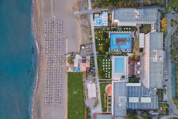 Luftaufnahme des Blue Sea Beach Resorts mit Strand, Swimmingpools und Hotelgebäuden.