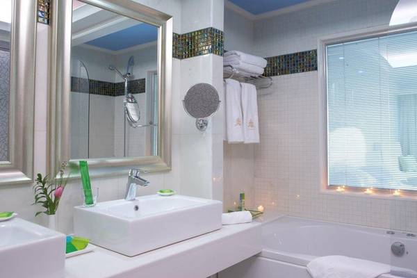 Badezimmer im Atrium Platinum Luxury Resort Hotel & Spa mit Badewanne, Waschbecken und Spiegel.
