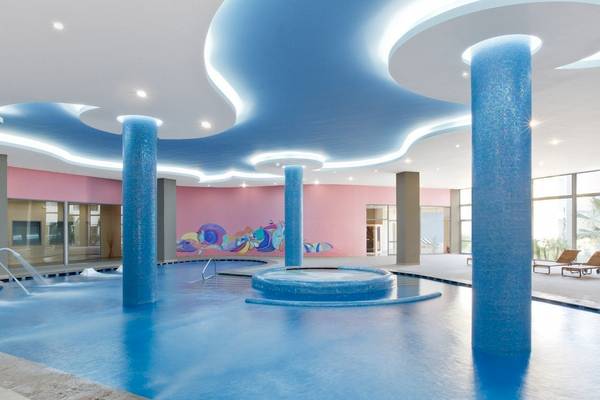 Innenpool des Atrium Platinum Luxury Resort Hotel & Spa mit blauen Säulen und bunter Wand