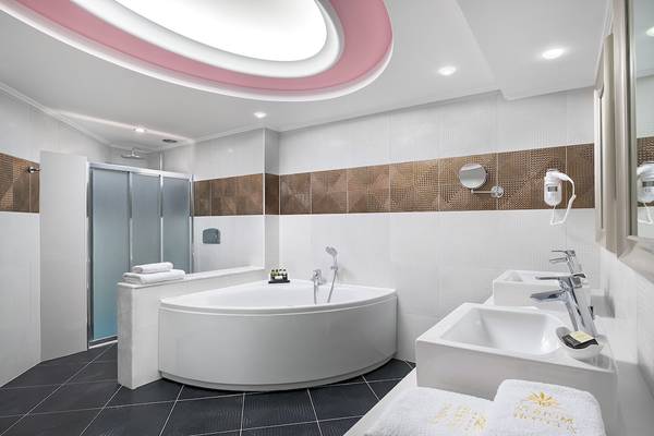 Badezimmer mit Badewanne, zwei Waschbecken und Dusche im Atrium Platinum Luxury Resort Hotel & Spa.