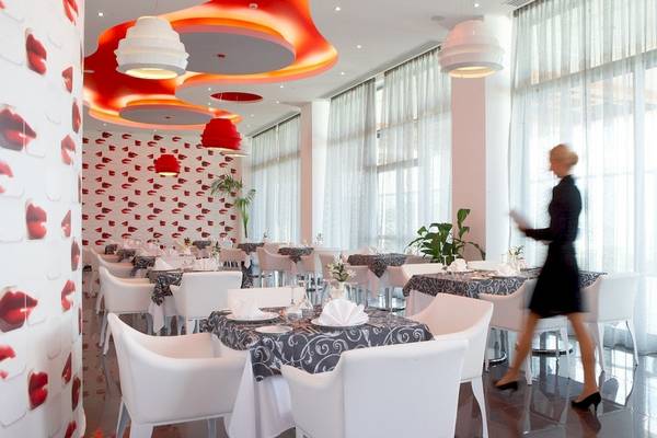 Innenraum des Atrium Platinum Luxury Resort Hotel & Spa mit roten Lippenmotiven und weißen Möbeln.