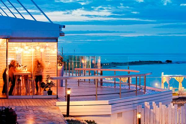 Terrasse des Knossos Beach Bungalows Suites Resort & Spa bei Nacht mit Meerblick