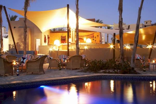 Außenbereich des PickAlbatros Oasis Port Ghalib Hotels mit beleuchteten Pool und Sitzbereich bei Nacht