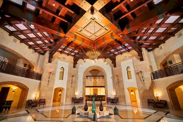 Innenansicht der Lobby des Pick Albatros Oasis Port Ghalib Hotels mit einer hohen Holzdecke und einem zentralen Brunnen.