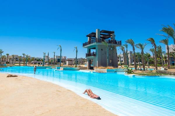 Ein großer Pool am PickAlbatros Oasis Port Ghalib Hotel mit einer Frau, die sich entspannt.