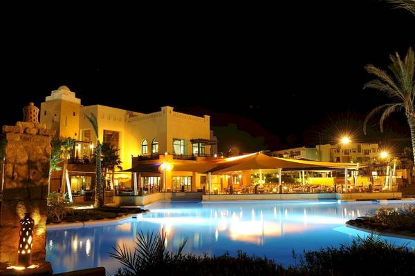 PickAlbatros Oasis Port Ghalib Hotel bei Nacht mit beleuchtetem Swimmingpool und Gebäuden.