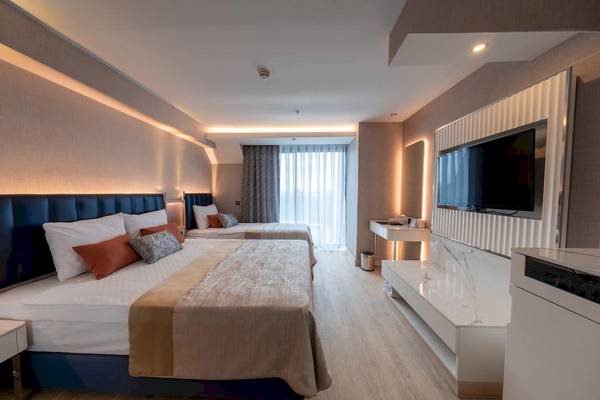 Doppelzimmer im Lago Hotel mit zwei Betten, Fernseher und modernen Möbeln.