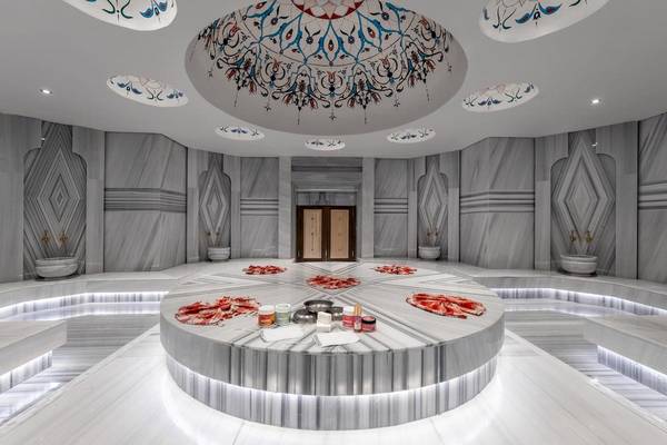 Innenansicht der Sauna im Lago Hotel mit Marmorwänden und einer zentralen Tischfläche.