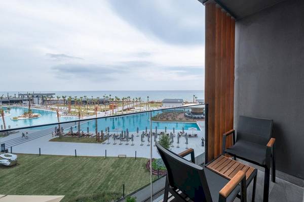 Aussicht vom Balkon des Lago Hotels mit Swimmingpool und Meer im Hintergrund.