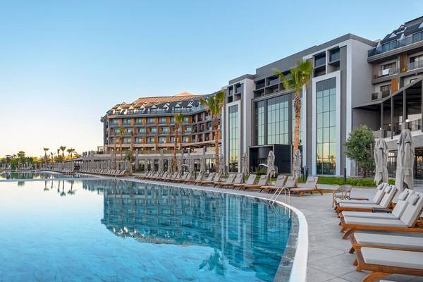 Außenbereich des Lago Hotels mit Swimmingpool und Sonnenliegen