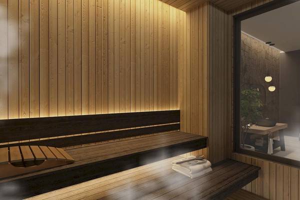Innenansicht der Sauna im Lago Hotel mit Holzwänden und Bänken, Beleuchtung und einem Fenster.