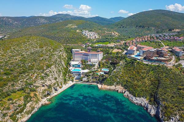 Luftaufnahme von Ladonia Hotels Adakule mit Meer und Bergen im Hintergrund.