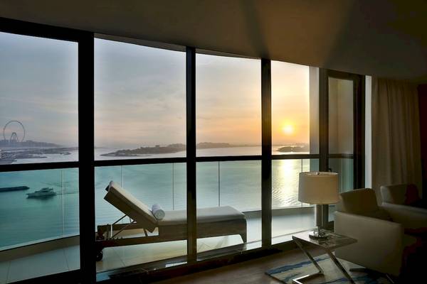 Ausblick aus dem Zimmer des Marriott Resort Palm Jumeirah in Dubai mit einem Sonnenuntergang und Blick auf das Meer und einen Riesenrad.